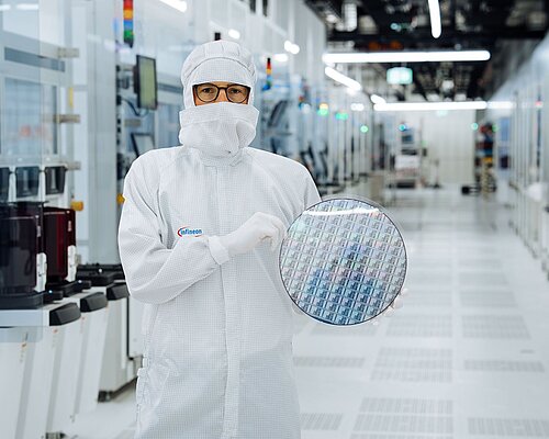 Technician in a clean room with the new GaN300 wafer